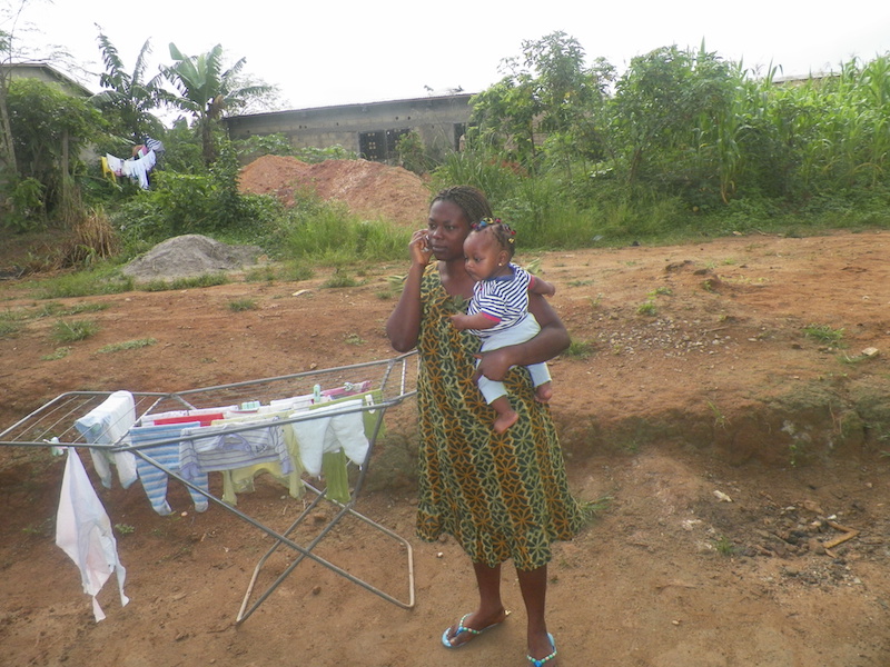 A mother using telephone to get text messages of useful health related information for her six months old baby in Idenau-Limbe (PHOTO: ClimateReporters/Elias Ntungwe)