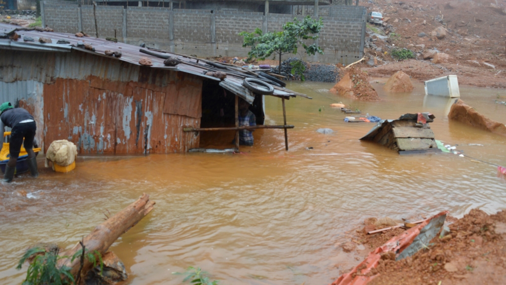 Residents save belongings in floodwaters after a mudslide in the mountain town of Regent, Sierra Leone on August 14, 2017 [Ernest Henry/Reuters]