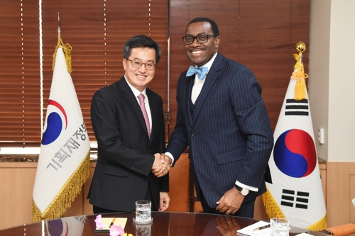 South Korea's finance minister Kim Dong-yeon (L) shakes hands with Akinwumi Adesina, president of the African Development Bank (AfDB) in Seoul, on March 13, 2018. (Yonhap)